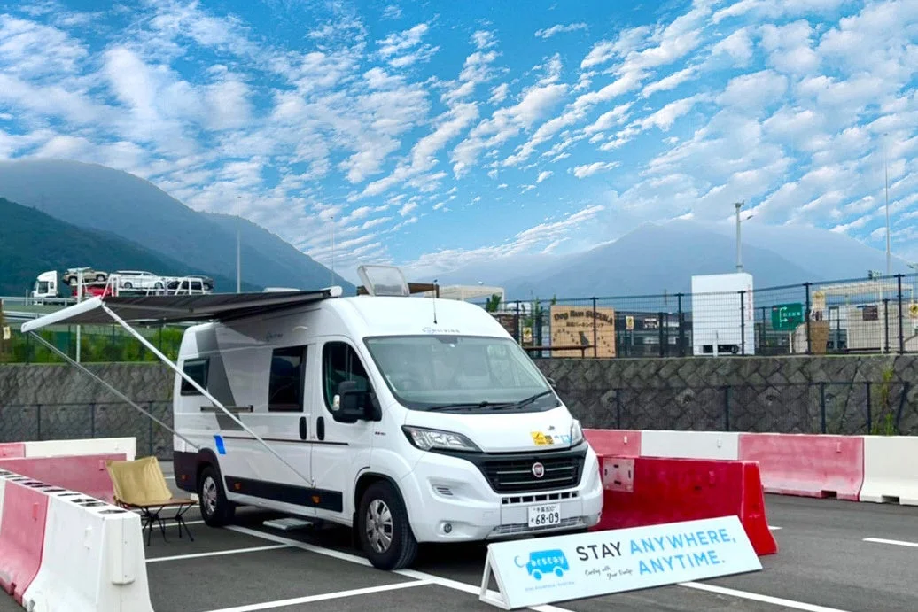 青空の下、サービスエリアに停まるキャンピングカー