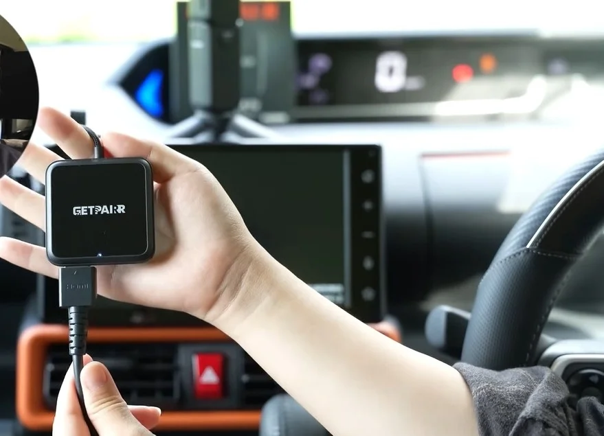 車内で黒い四角いデバイス「GETPAIR」をUSBケーブルで接続している様子