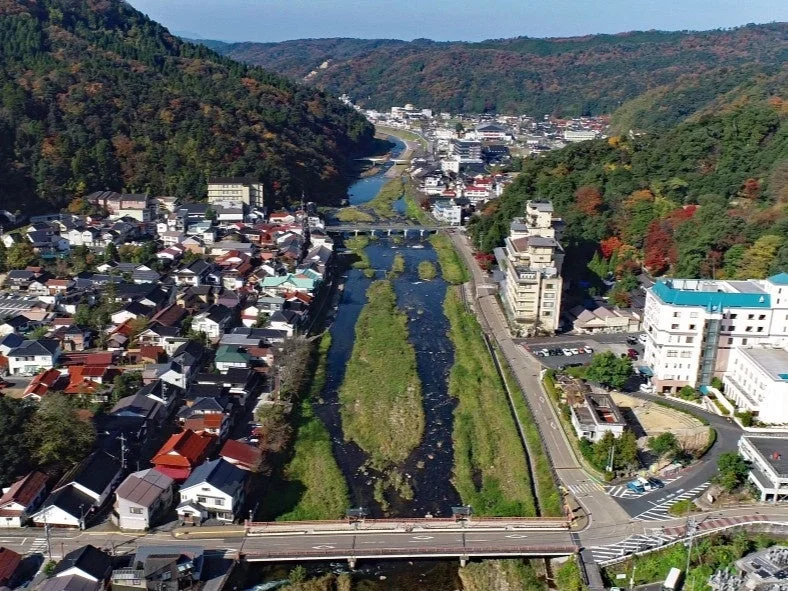 紅葉が始まった山々に囲まれた日本の街並み