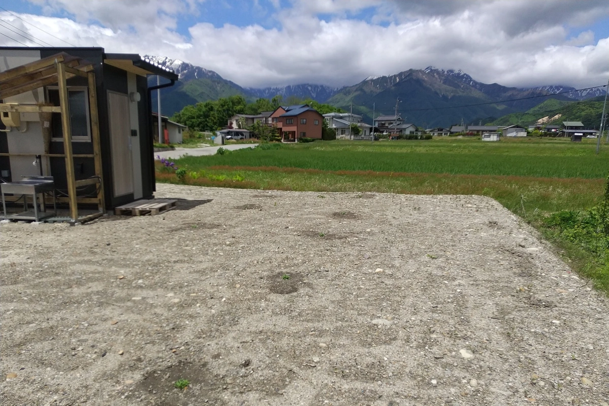 残雪を抱く山々を背景にした日本の田園風景