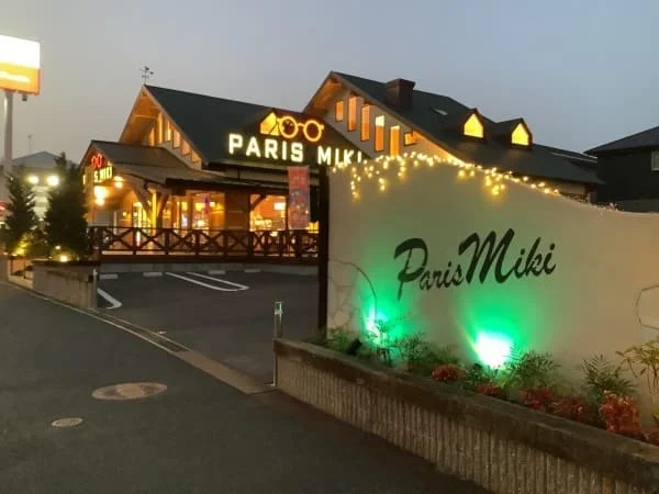 夕暮れ時にライトアップされたパリミキの店舗外観です。