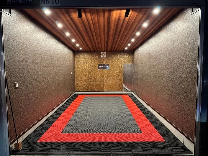 赤と黒のタイル張りの床と木目調の天井が特徴的なモダンな室内空間