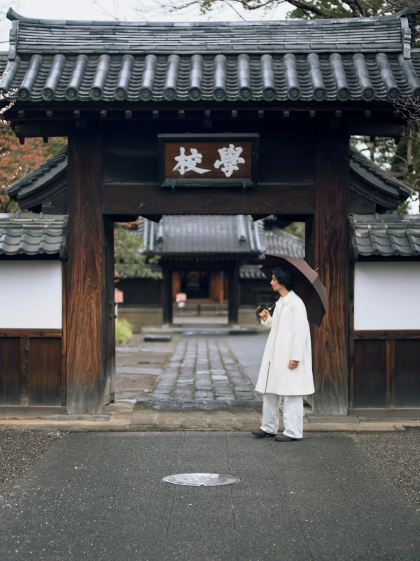 伝統的な門の前に立つ斎藤工さん