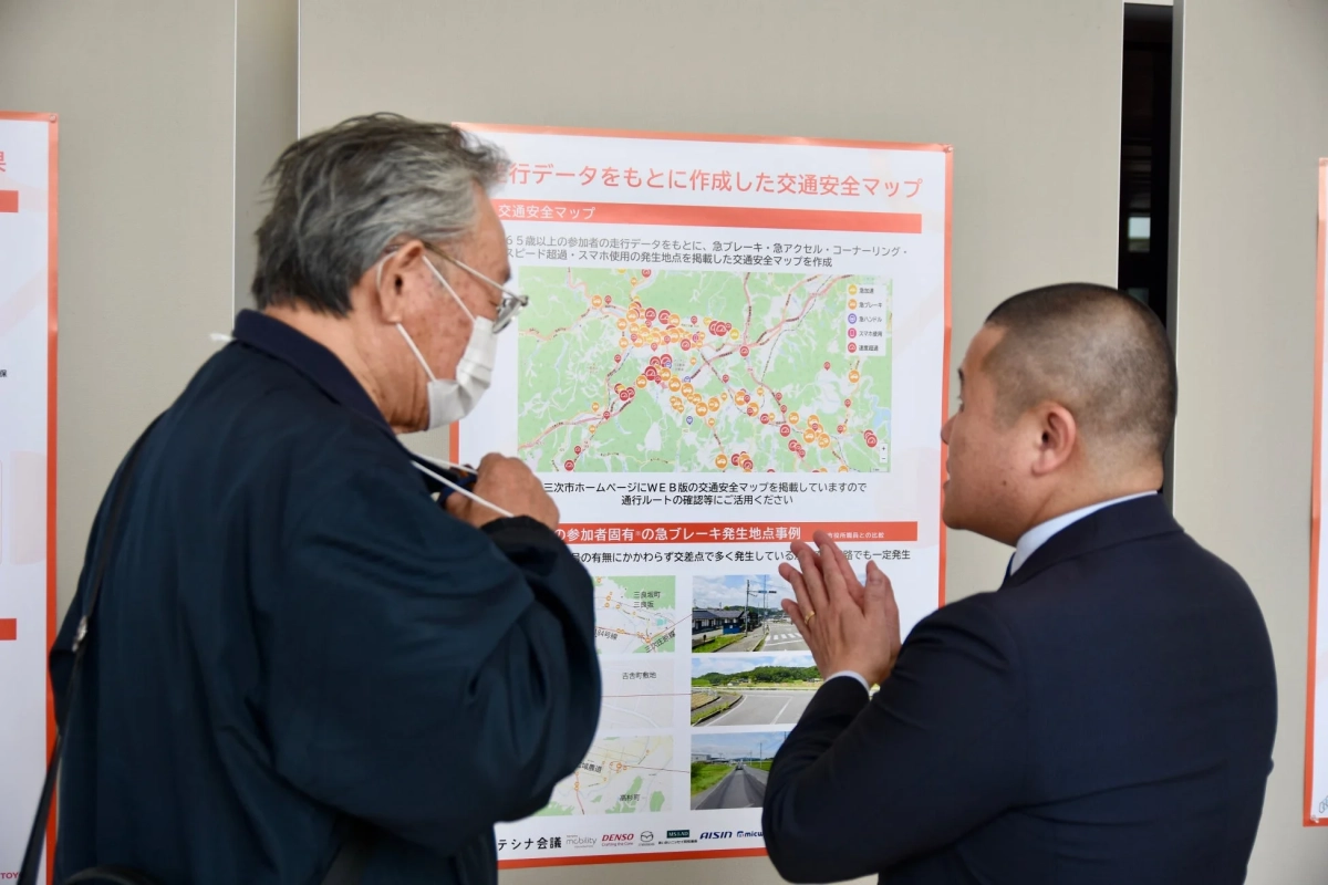 交通安全マップに関するポスターを見ながら話す二人