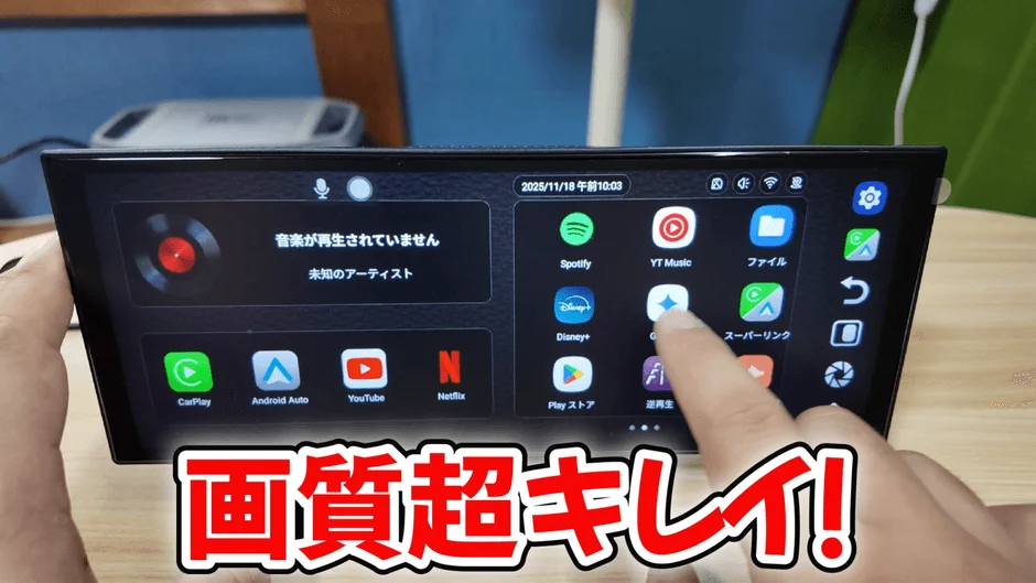 車載ディスプレイのホーム画面が映されており、SpotifyやYouTubeなどのアプリが多数表示されています。画面下部には「画質超キレイ!」とあり、ディスプレイの高品質をアピールしています。