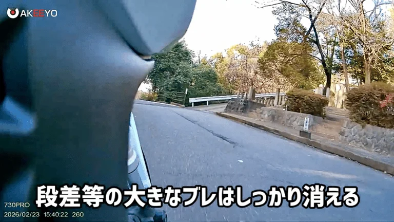 バイクの車載カメラ視点から見た、カーブのある山道の風景