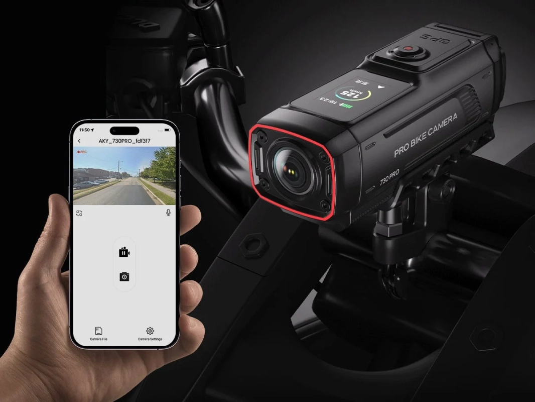 バイクに取り付けられた黒いアクションカメラと、そのライブ映像や操作画面を表示しているスマートフォンの手元
