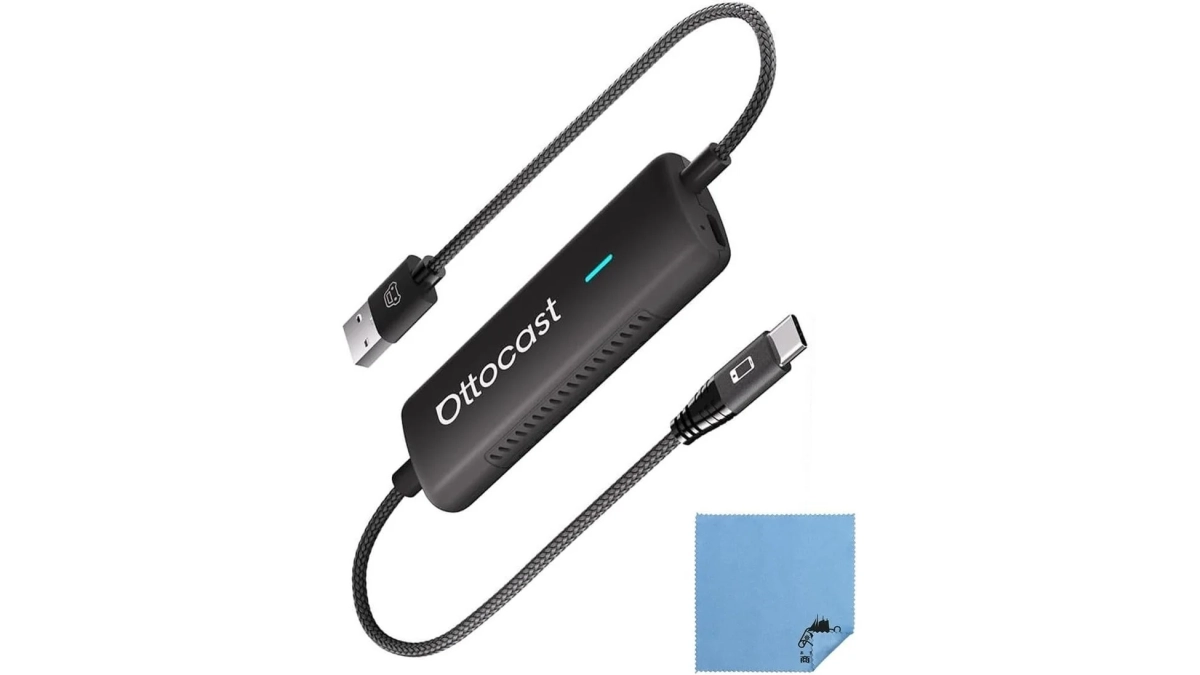 Ottocastブランドのワイヤレスカーアダプターと、それにつながるUSBケーブル、そして付属の青いクリーニングクロスが白い背景に配置されています。車載用の電子機器です。