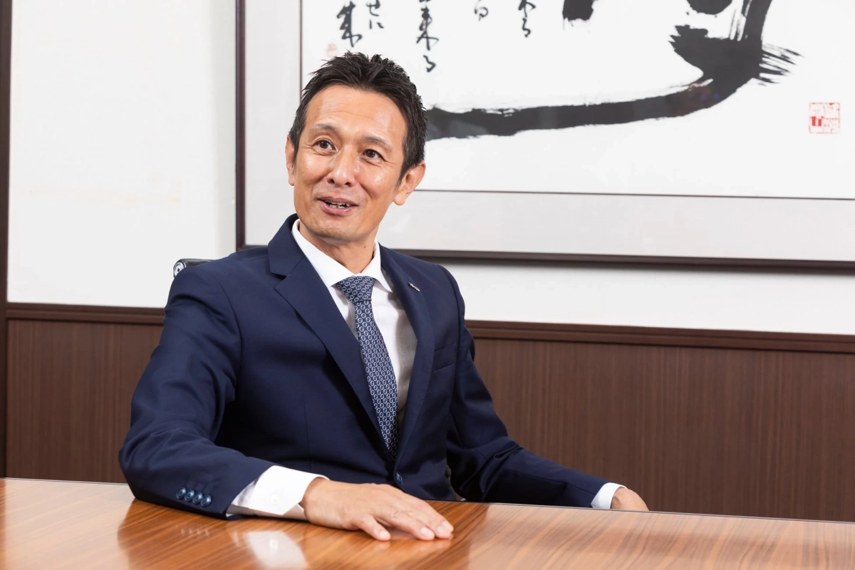 笑顔で座る日商の稲田一輝社長