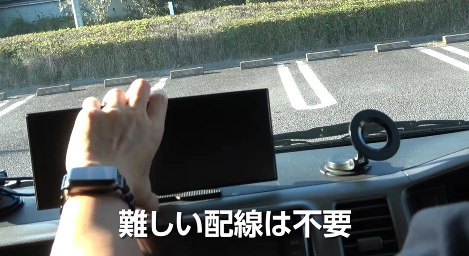 車のダッシュボードに設置されたデバイスを調整する手元が写っています。「難しい配線は不要」というテキストが表示されています。