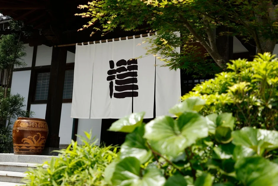 緑豊かな庭園に囲まれた日本家屋のエントランス。