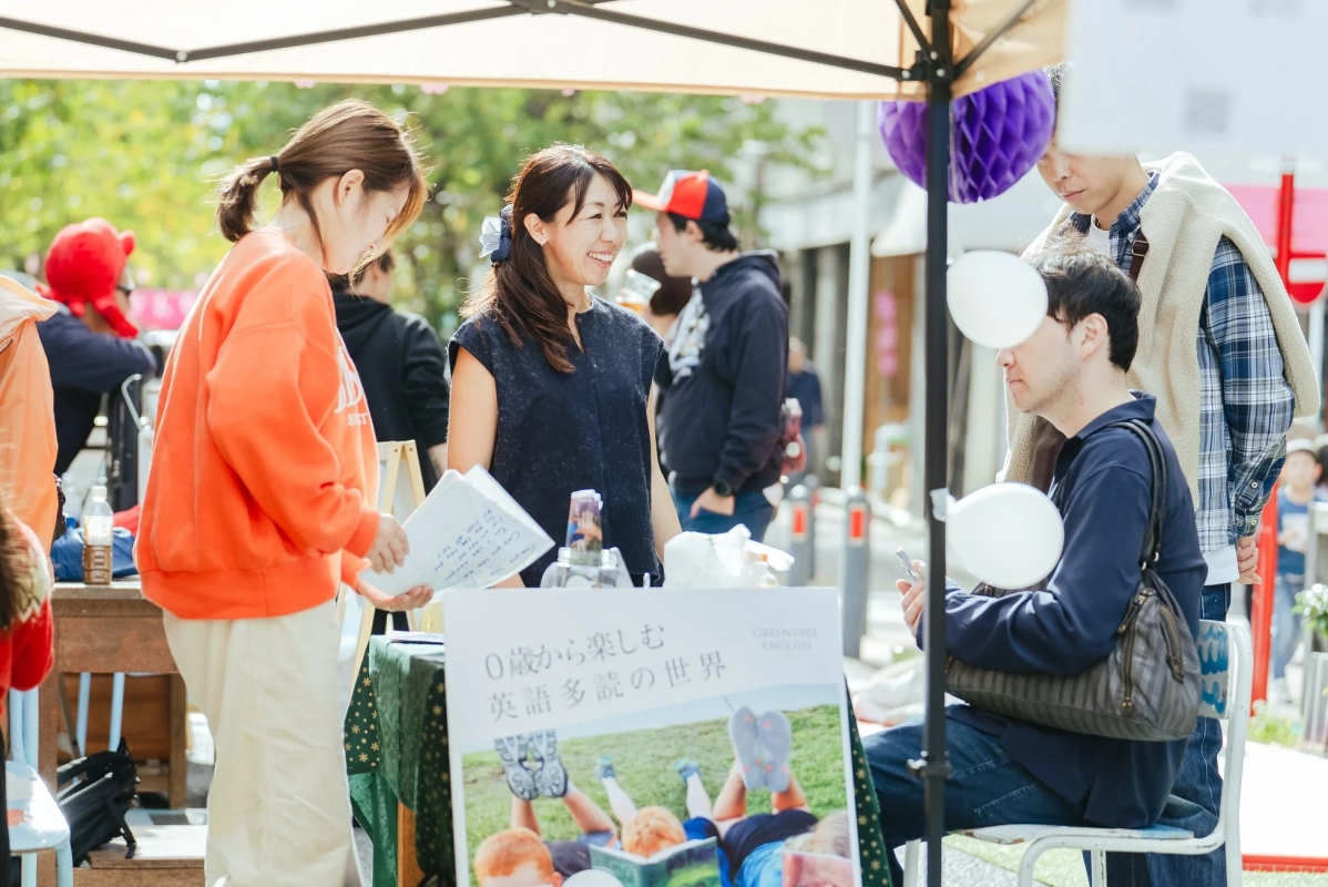 屋外イベントのブースで交流する人々の様子