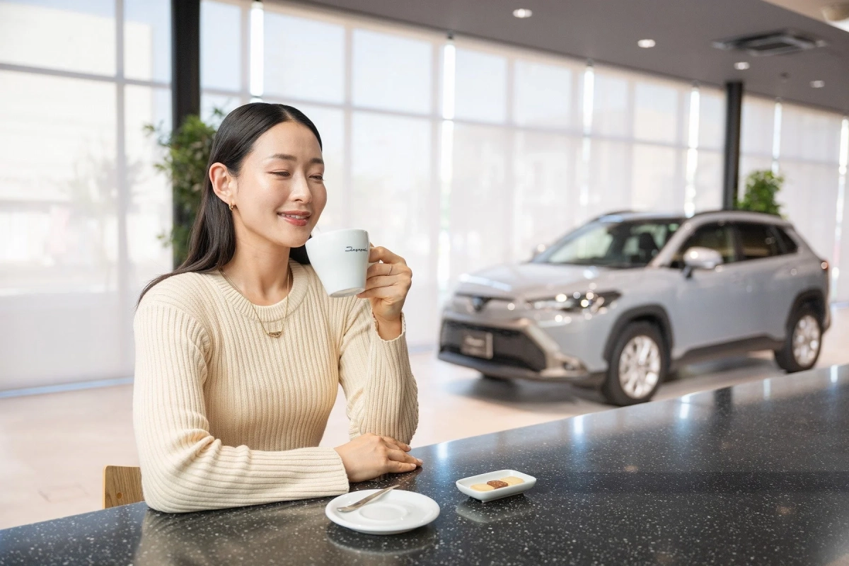 カフェ空間でコーヒーを飲む女性と車