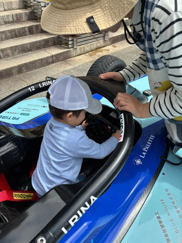 子供がレーシングカーに乗車している様子