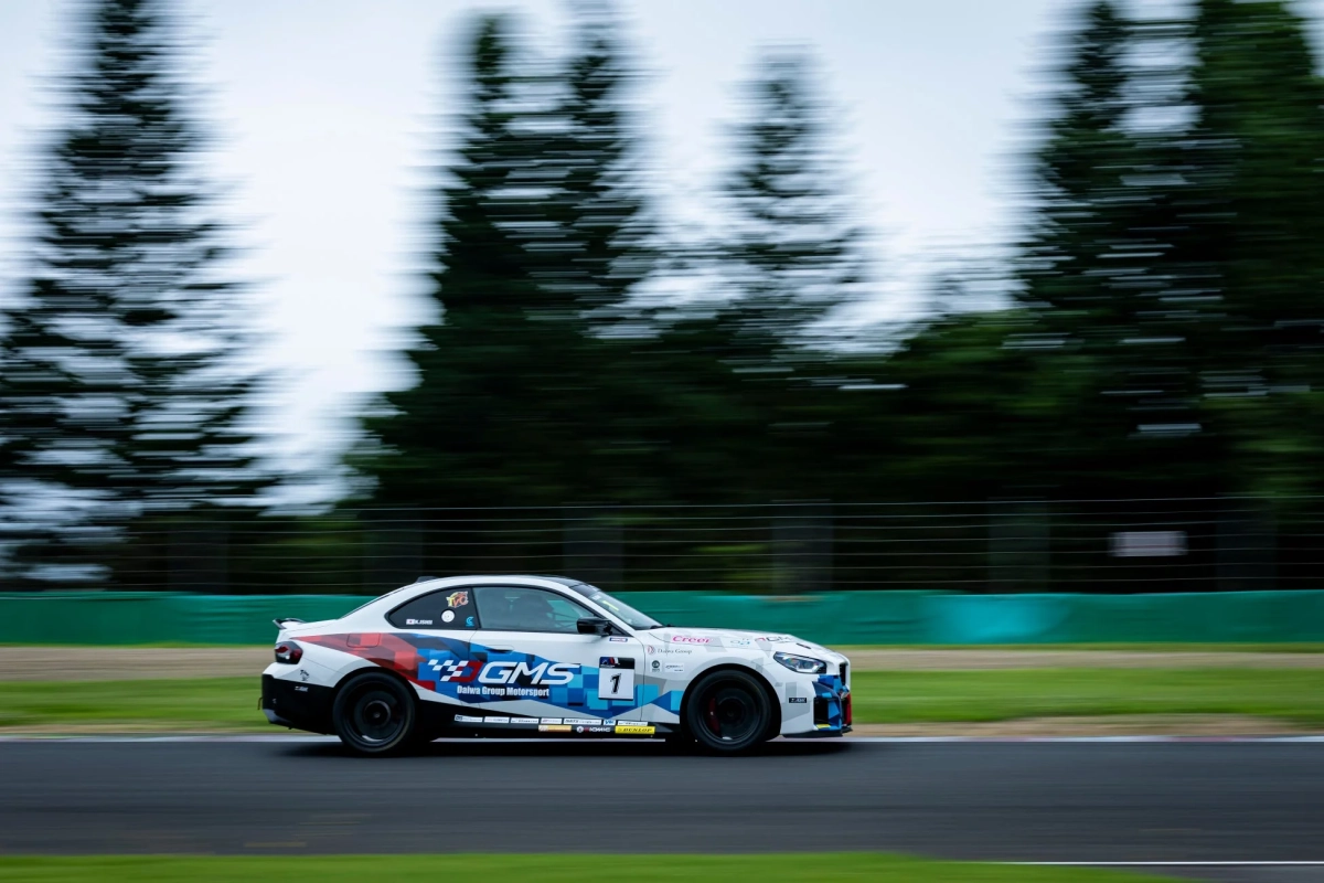 晴天のサーキットを高速で走行する白いレーシングカー