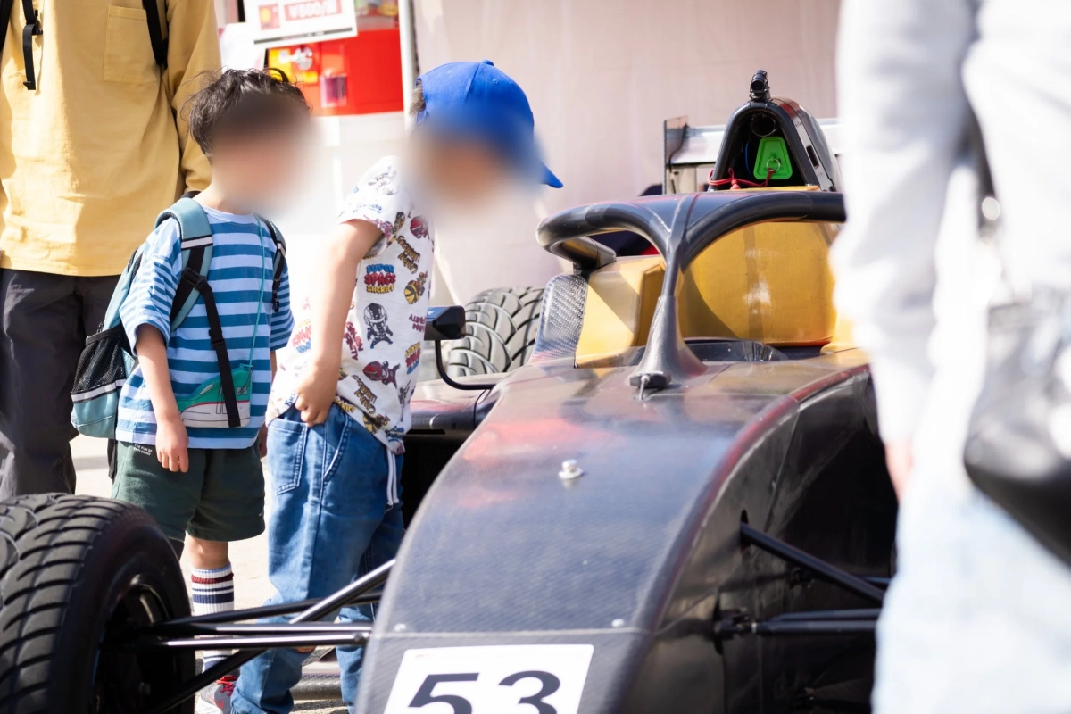 子供がレーシングカーを見ている様子