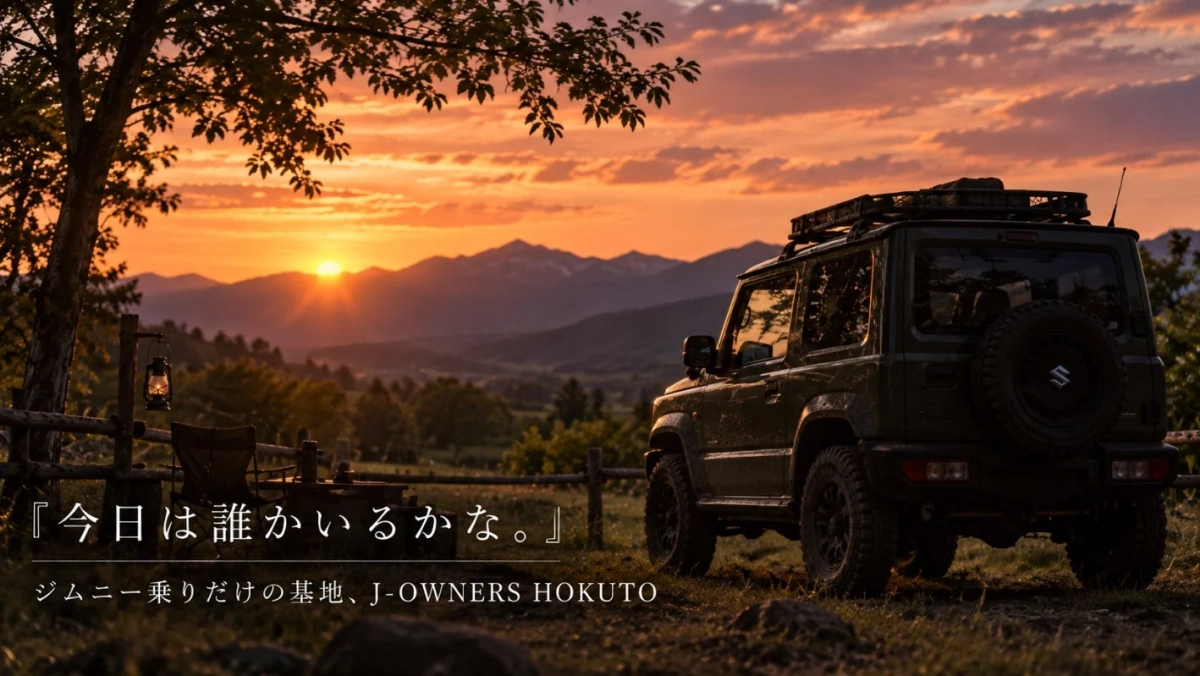 夕焼けに染まる山々を背景に、一台のダークグリーンのジムニーが丘の上に停まっています。左手には木とランタン、椅子があり、キャンプやアウトドアの雰囲気が漂う、美しい夕暮れの情景です。