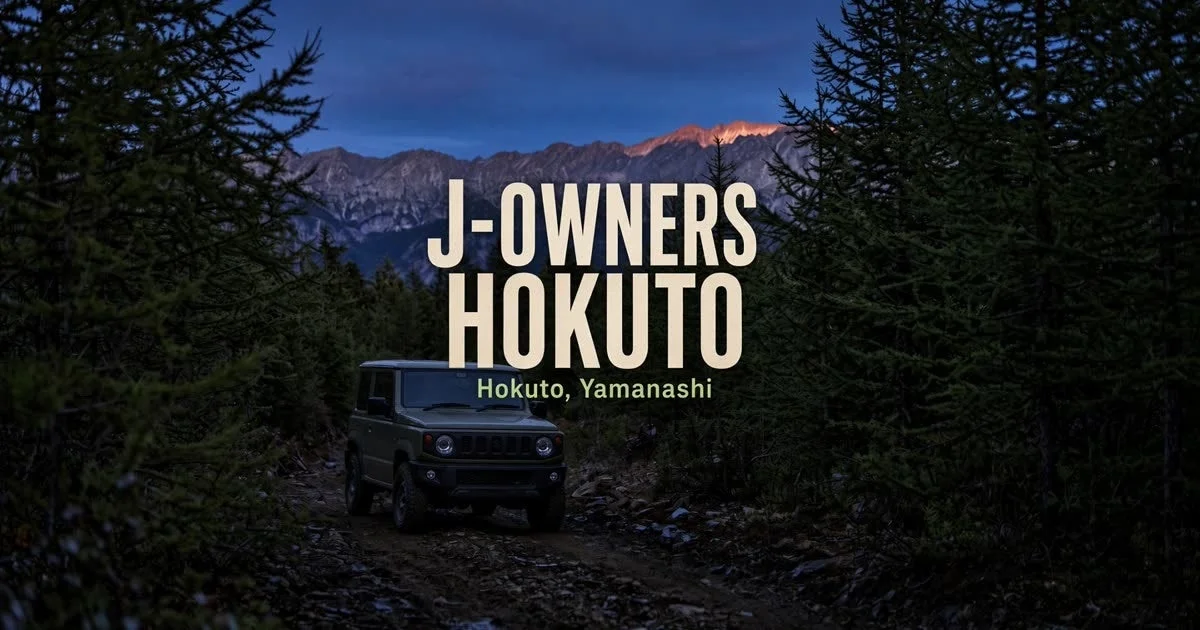 暗い森の未舗装路を進むSUV（おそらくジムニー）が描かれています。背景には山々が広がり、夕暮れか夜明けの空が印象的です。北杜市、山梨県が舞台のようです。